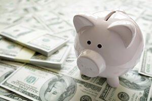 money beside a piggy bank to learn about Medicare affecting Health Savings accounts