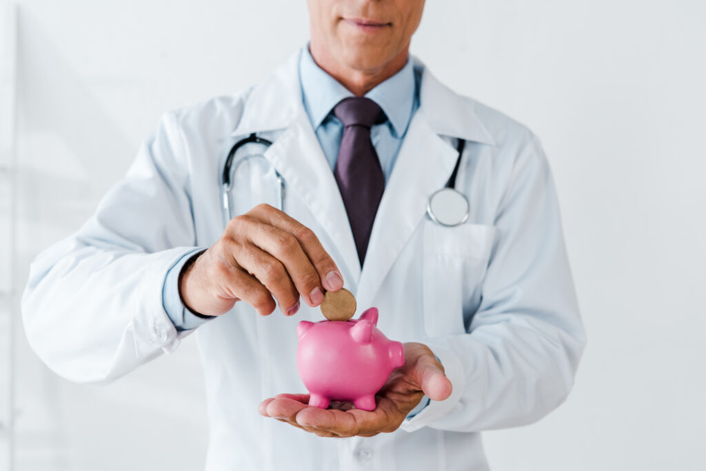 Doctor putting money into piggy bank to represent money saved with the Medicare Savings Program