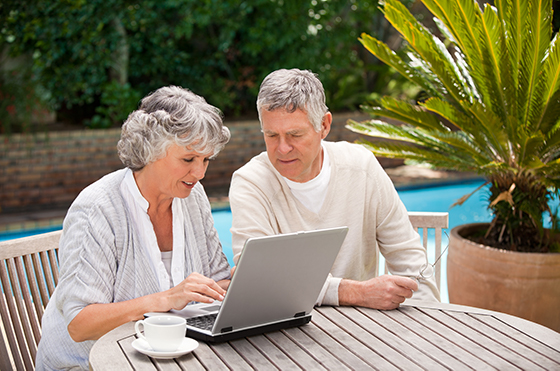 senior couple sitting with their computer learning how to create a medicare.gov account