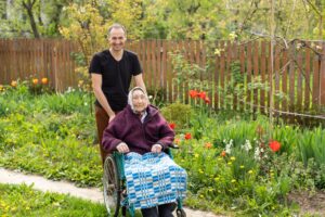 senior citizen on Medicare going through a garden with her caregiver