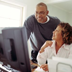 retired couple at a computer learning about retroactive election period for medicare